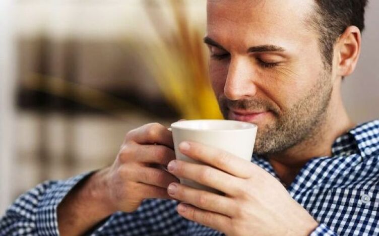 Un uomo beve una bevanda di tè all'epilobio per aumentare la potenza